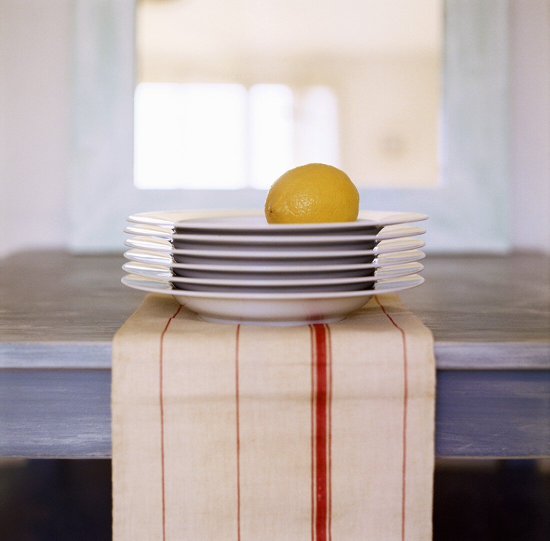 Pile of plates with a lemon