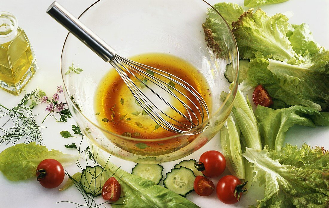 Stillleben mit Salatdressing und Salatzutaten