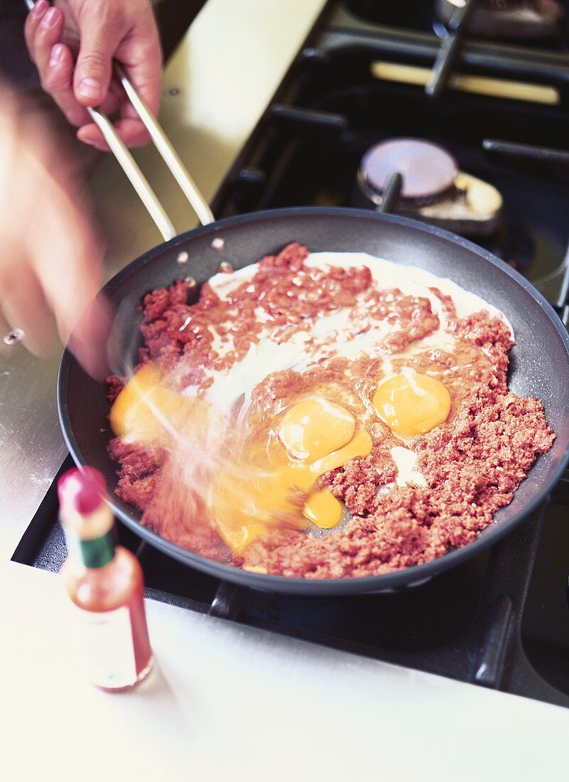 Corned beef with eggs in a frying pan