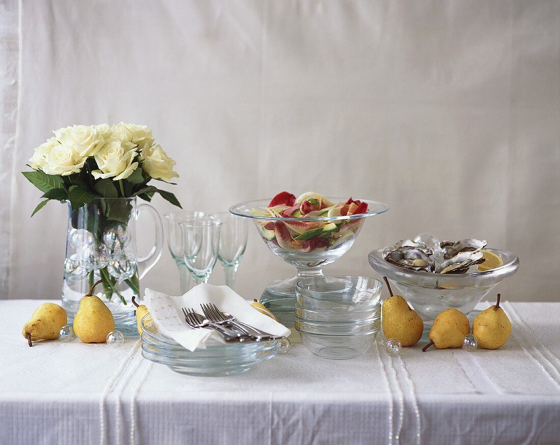 Buffet mit Austern, Salat, Birnen und weissen Rosen