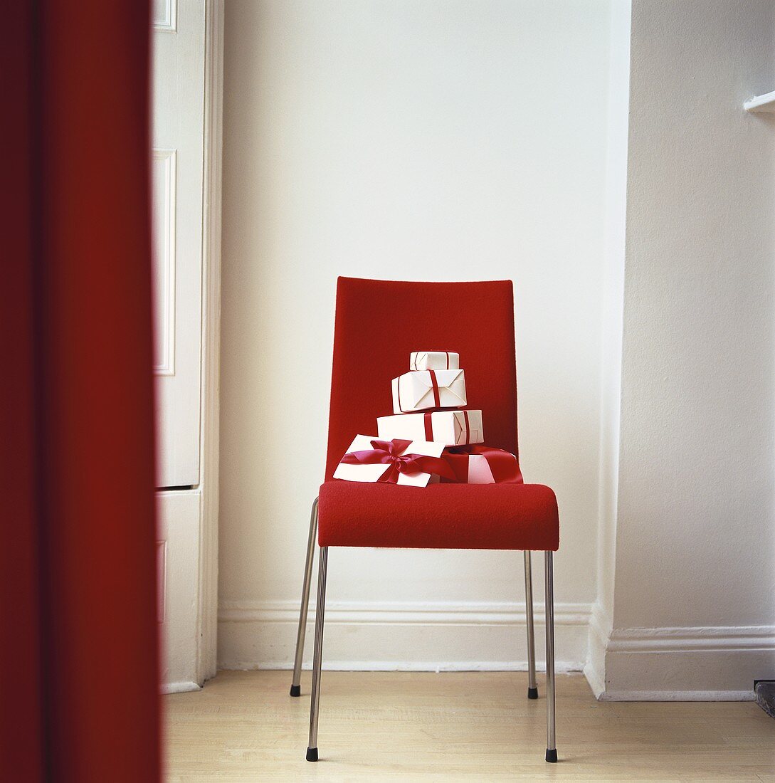Geschenkkartons auf rotem Stuhl