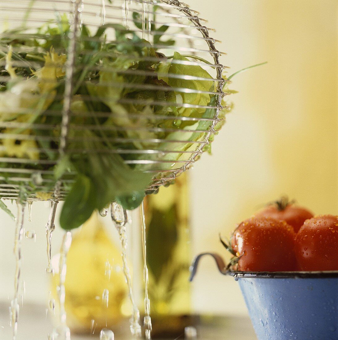 Salad in salad strainer and tomatoes