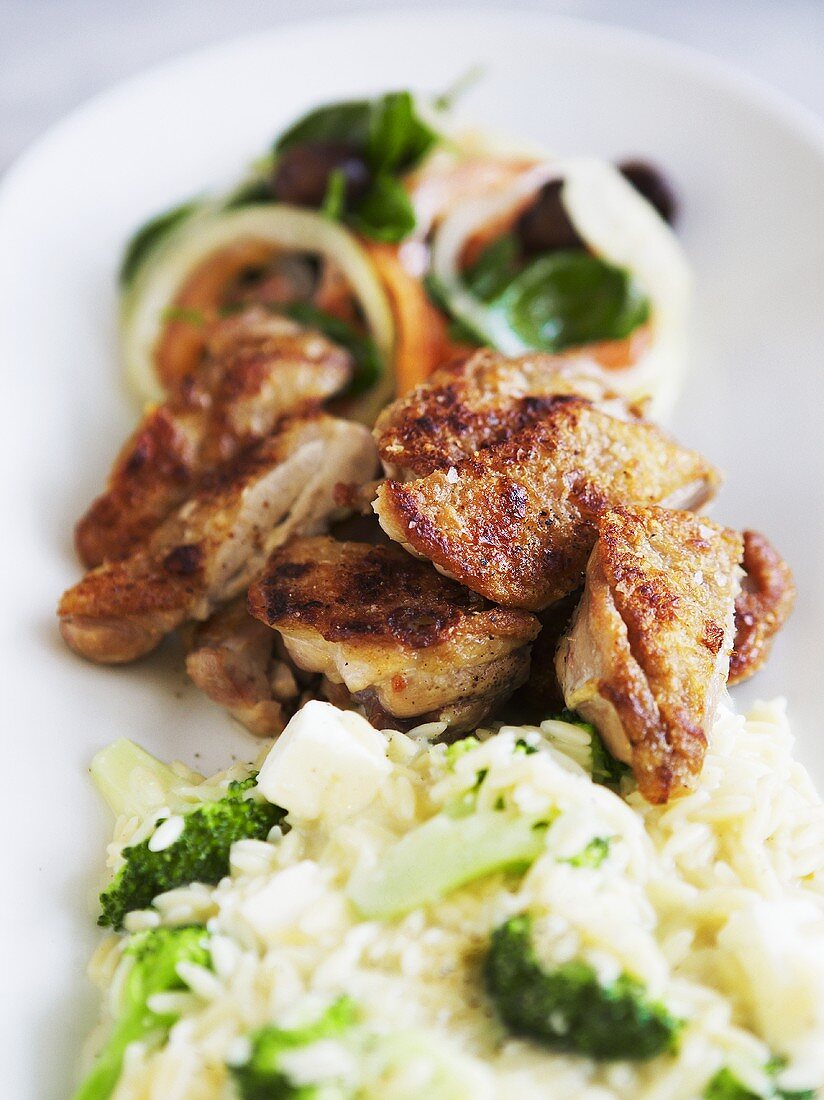 Fried chicken pieces with broccoli rice and salad