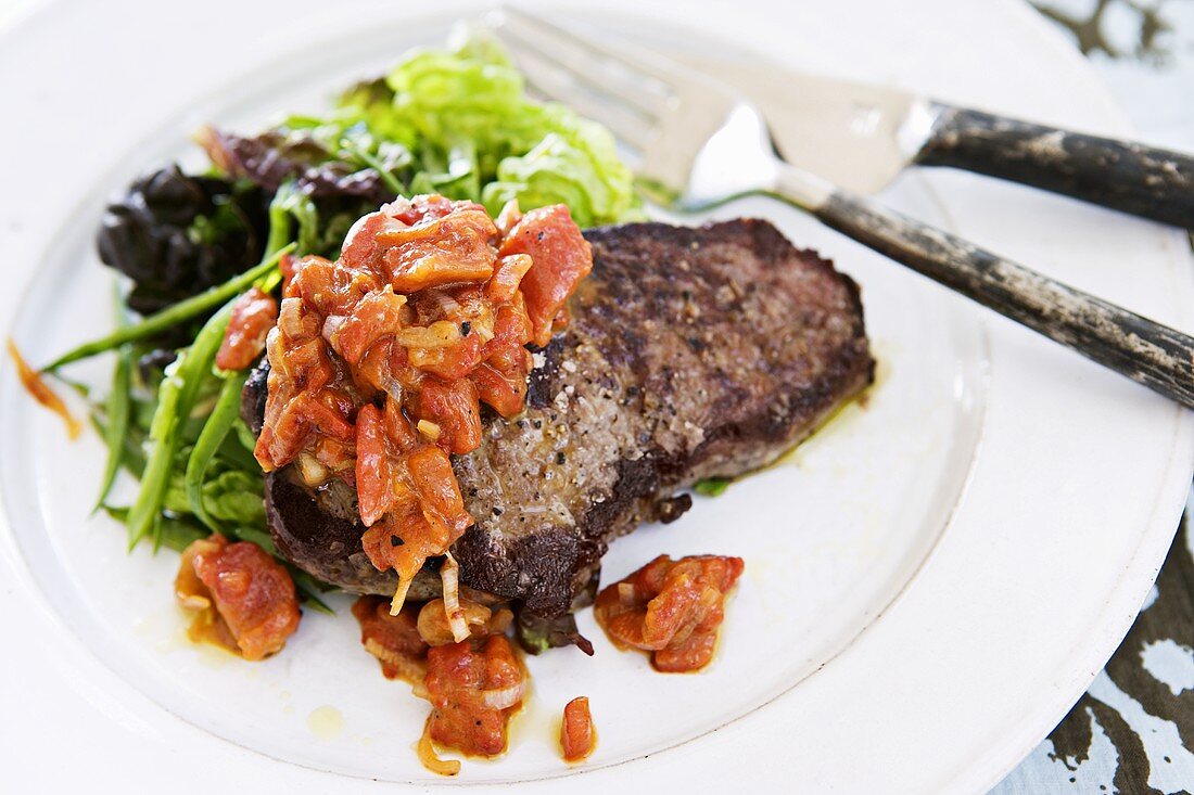 Beef steak with pepper sauce and salad