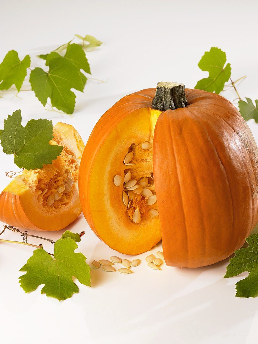 A pumpkin with a piece cut out and vine leaves