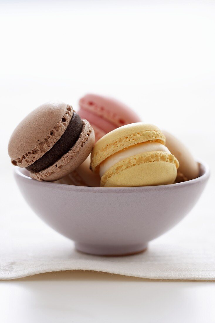 Assorted Luxemburgerli (filled macaroon biscuits) in a bowl