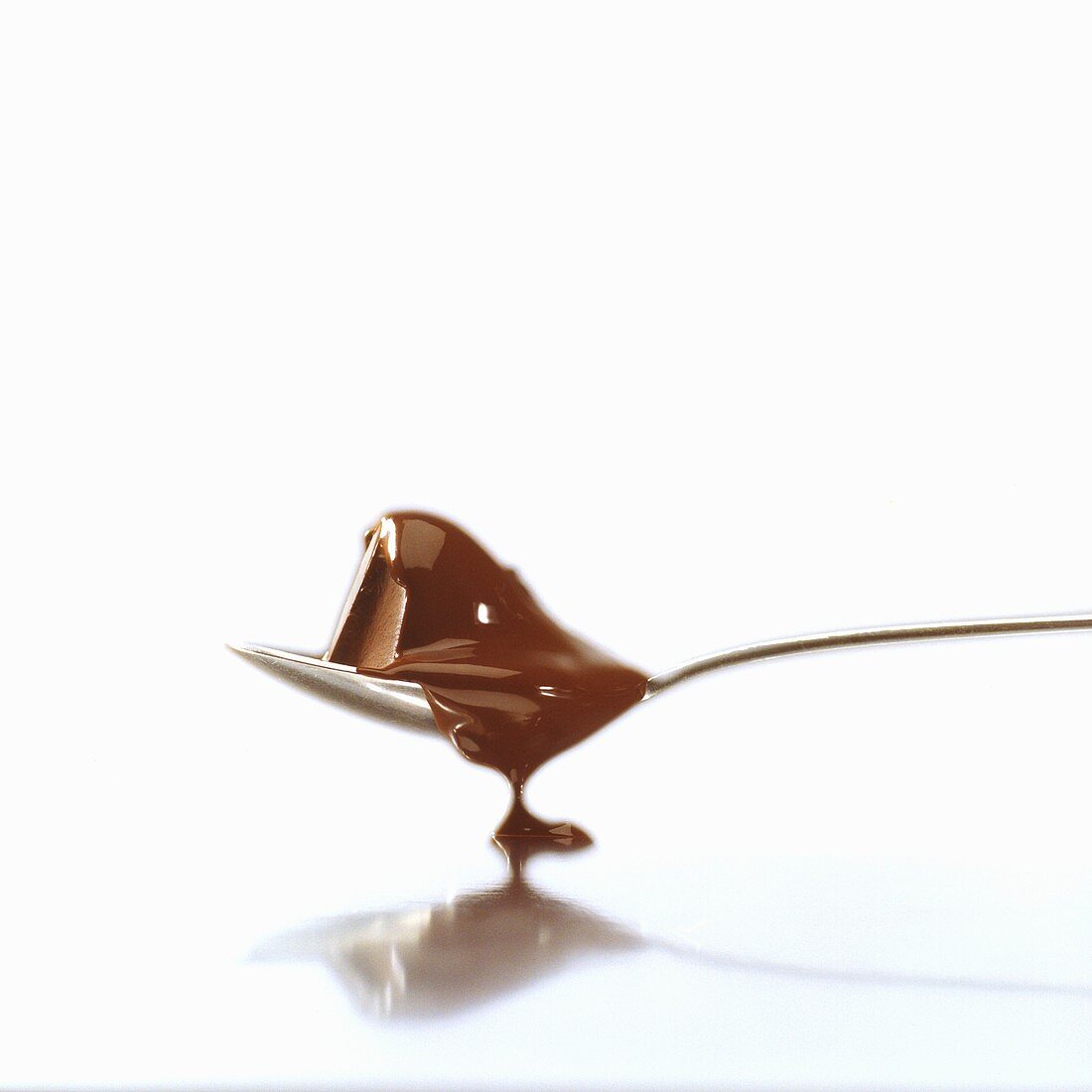 Schmelzende Schokolade fliesst vom Löffel