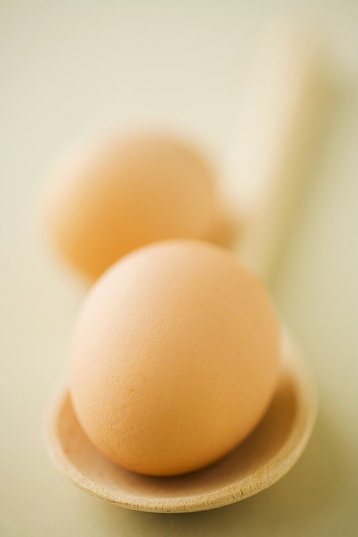 Two eggs with a wooden spoon