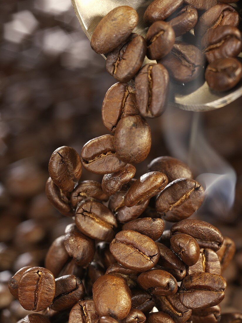 Freshly roasted coffee beans falling onto a heap