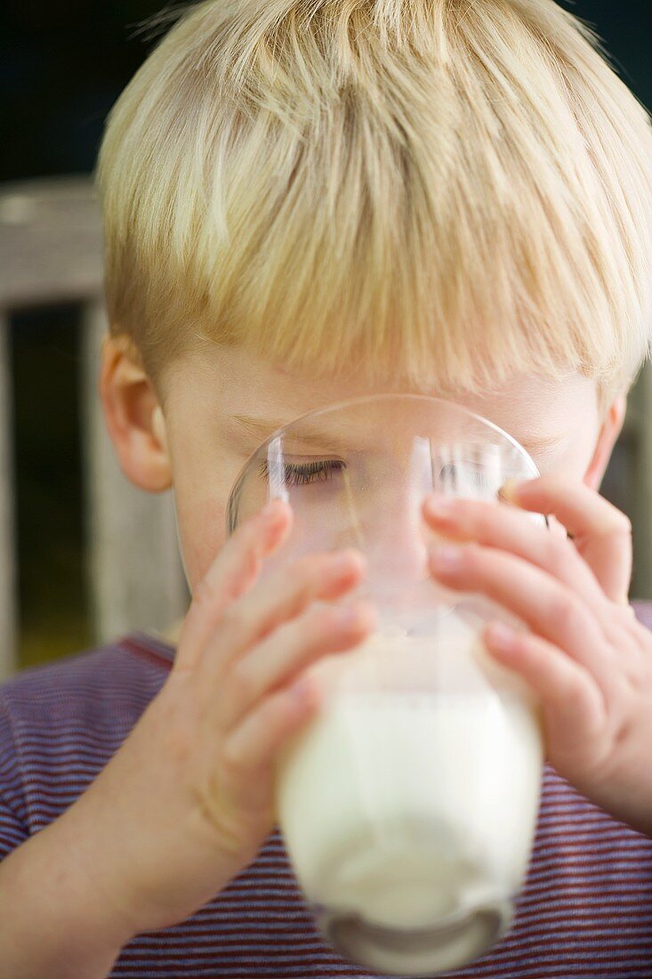 Kleiner Junge trinkt ein Glas Milch