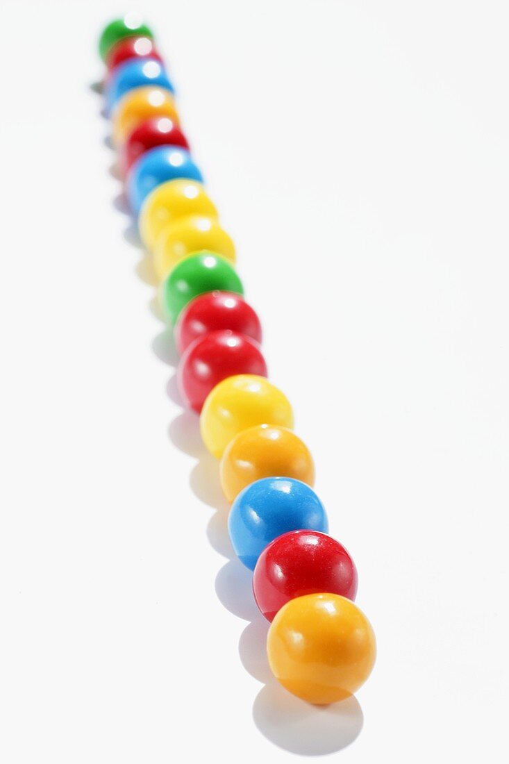 Lots of coloured chewing gum balls in a row