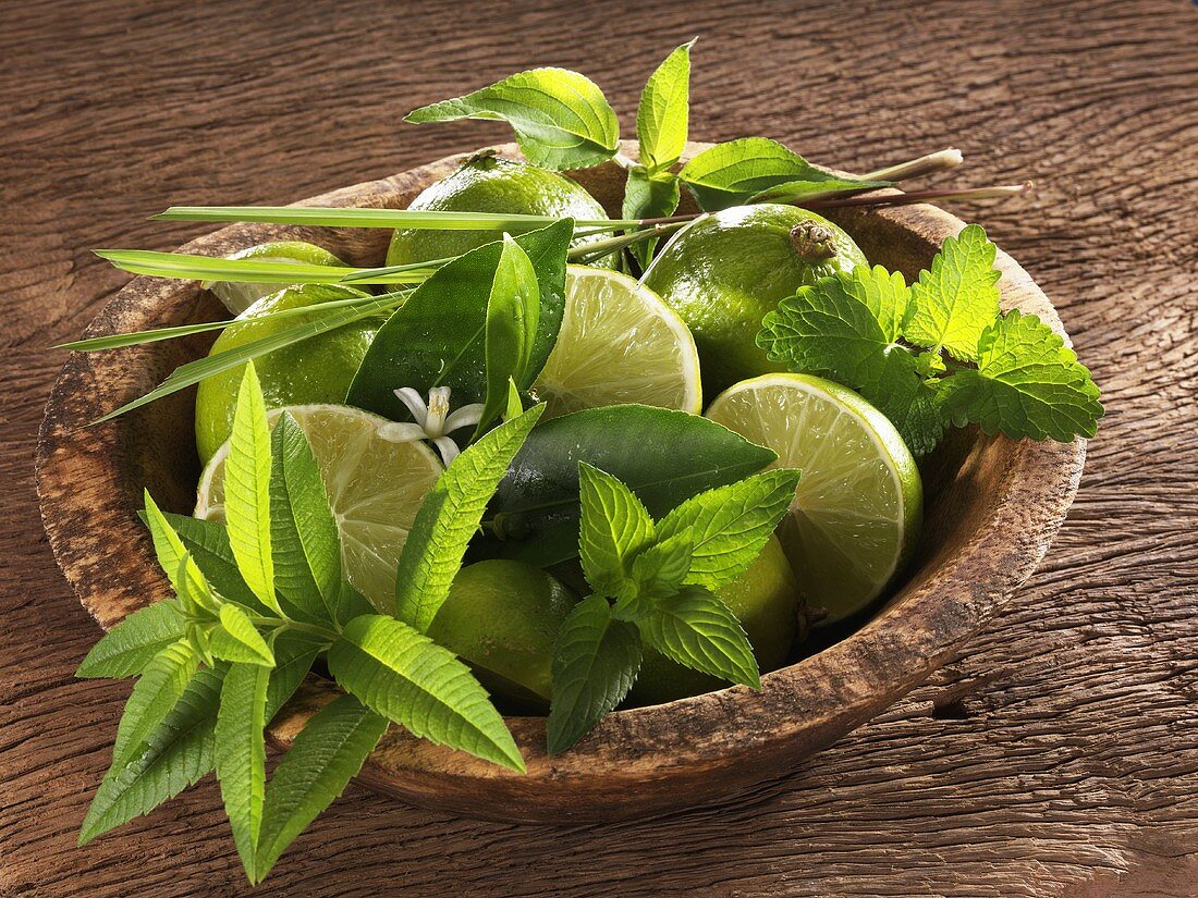 Limes and various herbs in a dish