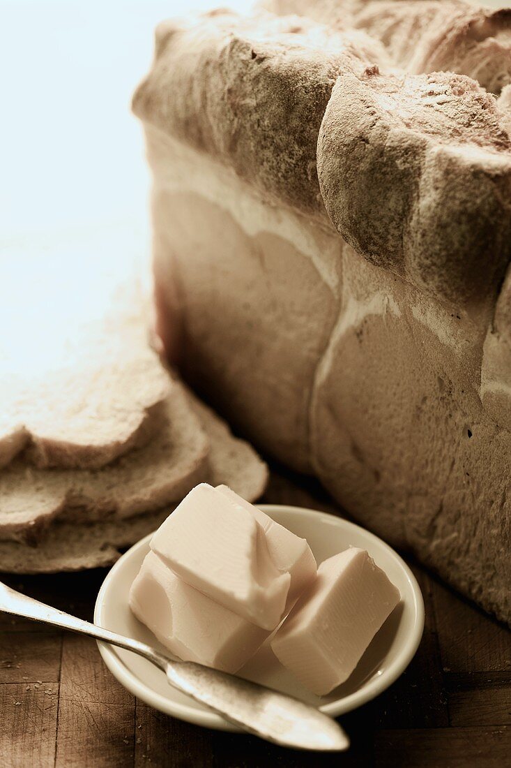 Butter auf einem Teller und Weißbrot