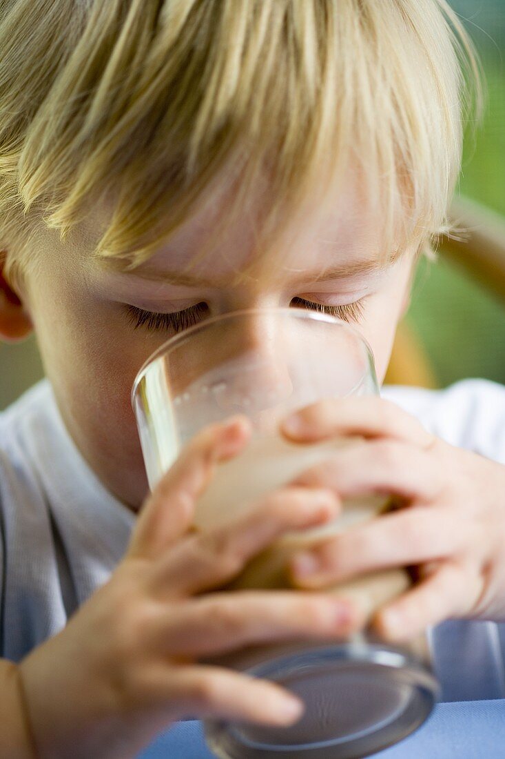 Small boy drinking a glass of cocoa