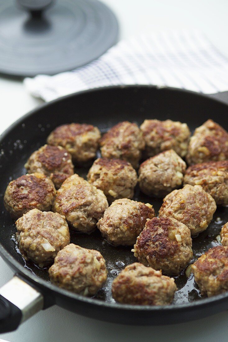 Spicy meatballs in frying pan