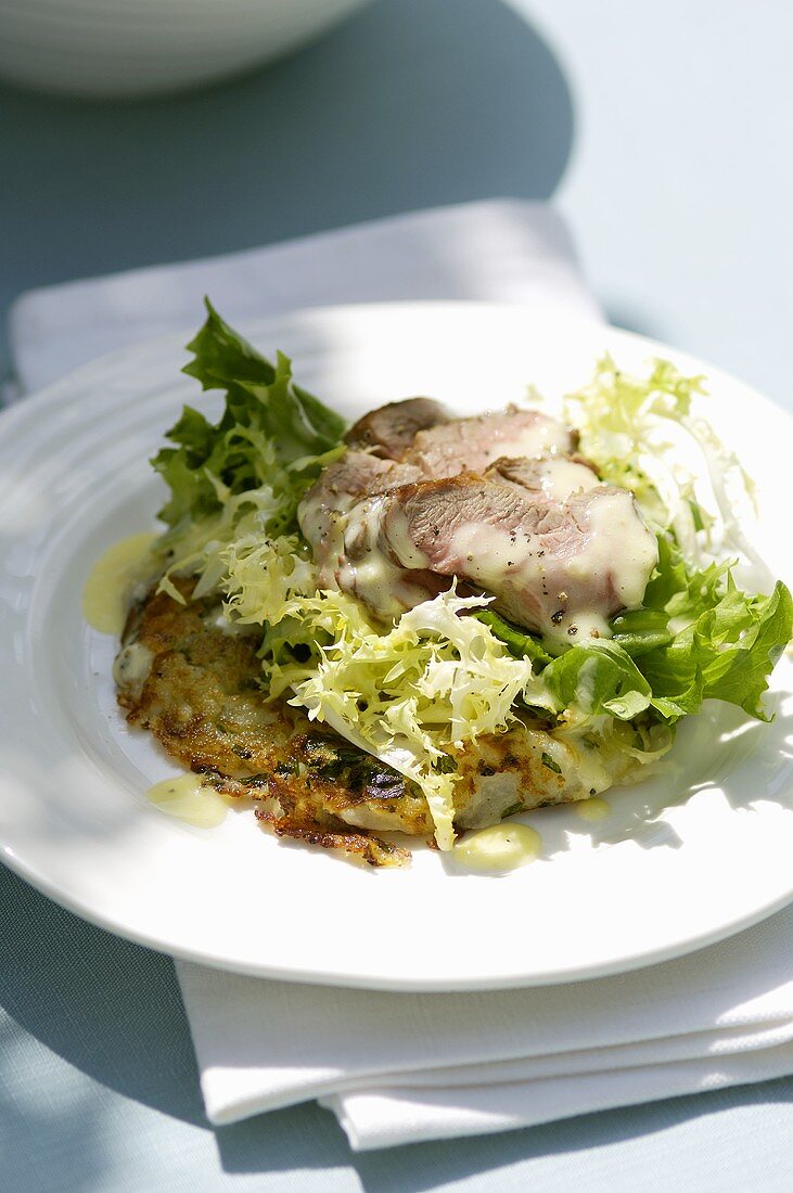 Salad leaves with roast lamb on potato rosti