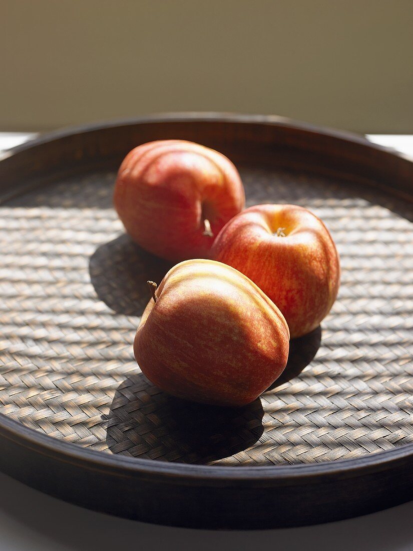 Three apples on a tray