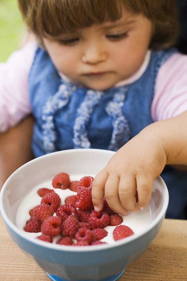 Small girl with raspberry yoghurt