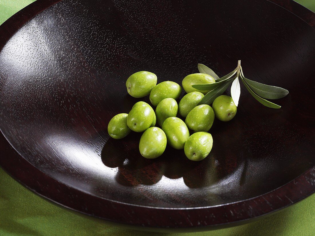 Fresh green olives in a wooden bowl