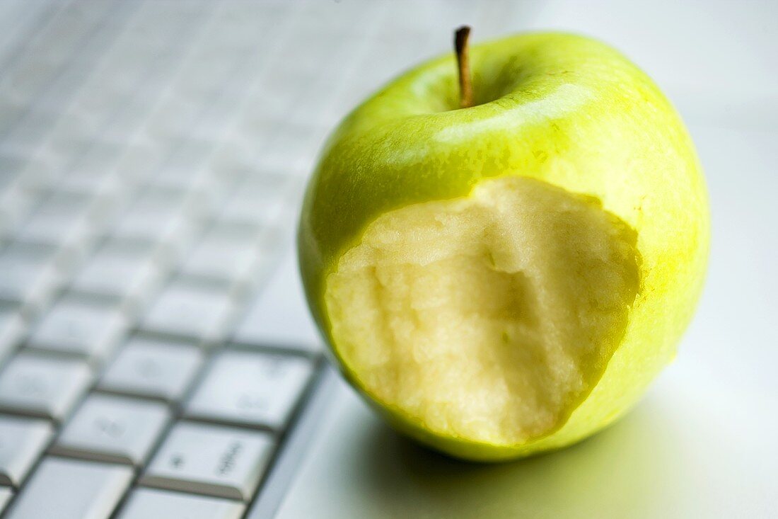 An apple with a bite taken on a computer