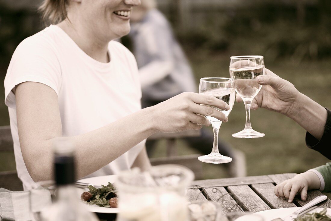 Raising white wine glasses during a meal
