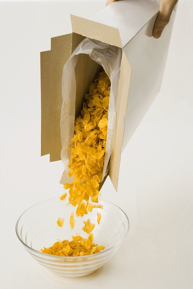 Tipping cornflakes into a bowl