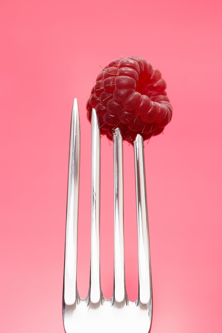 A raspberry speared on a fork
