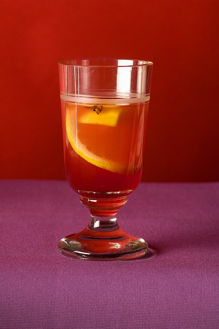 Ein Glas Punsch mit Orangenscheibe und Nelke