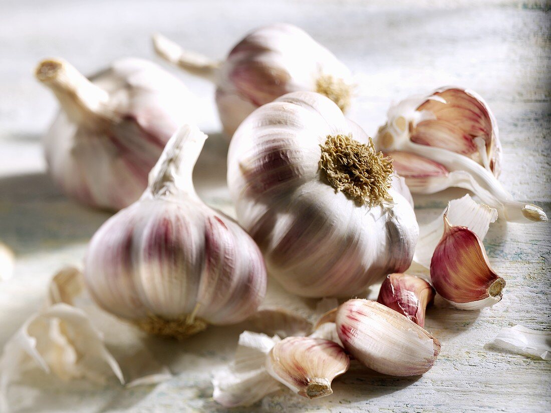 Four garlic bulbs and individual cloves of garlic