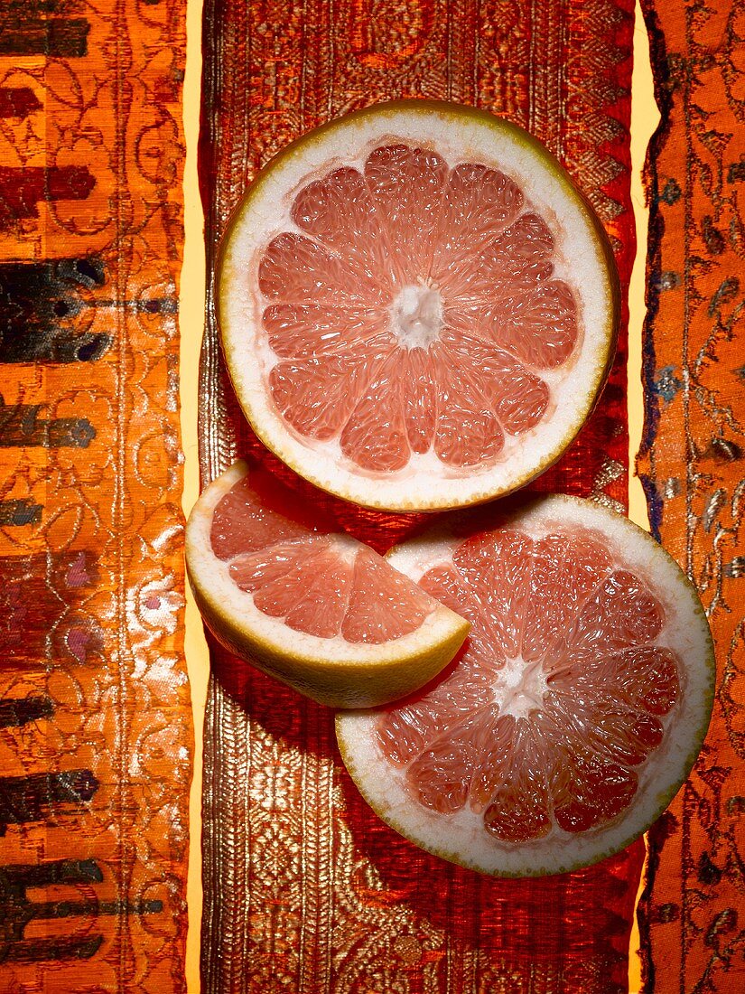 Two slices and one wedge of grapefruit