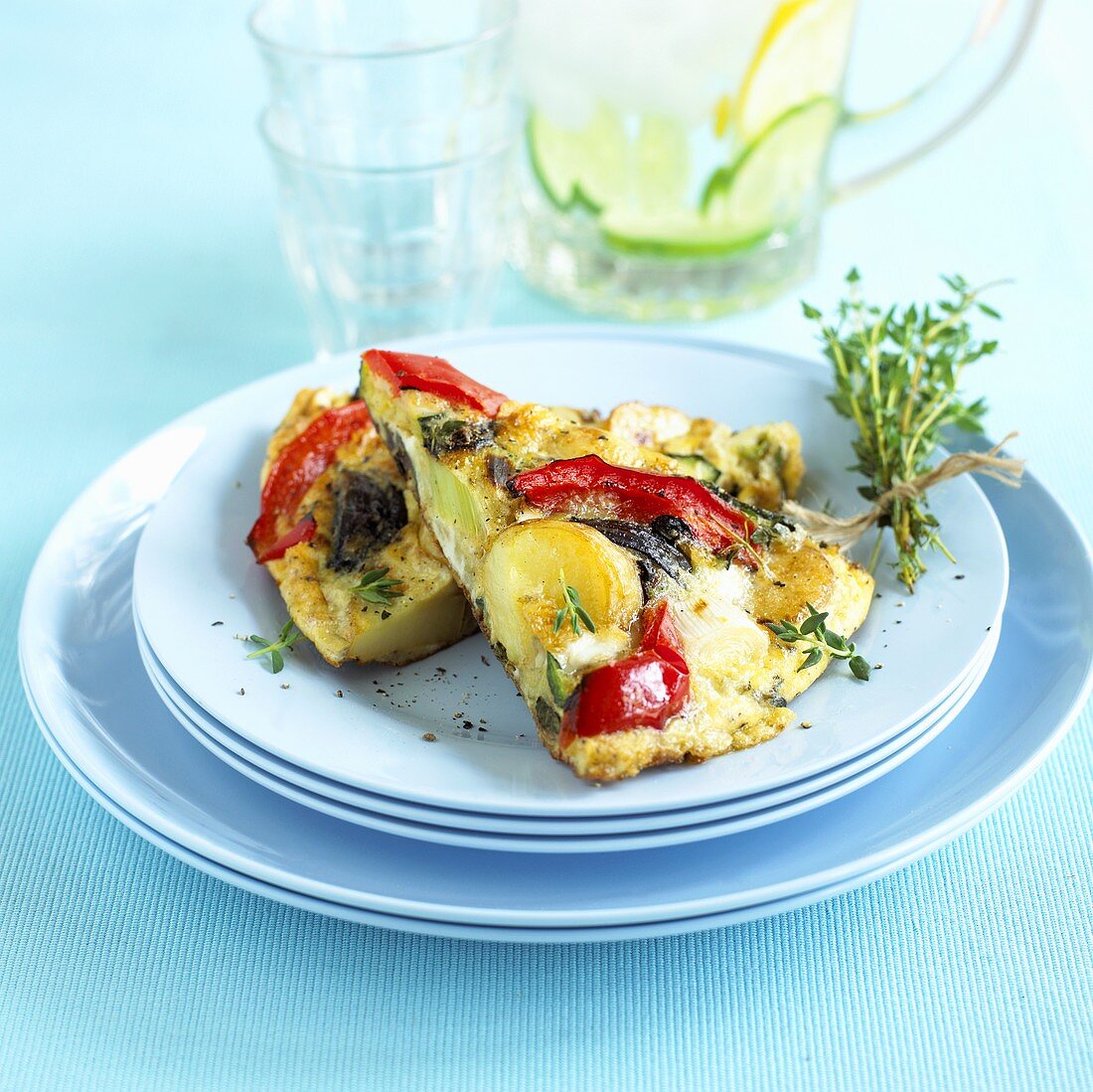 Two pieces of frittata on a pile of plates