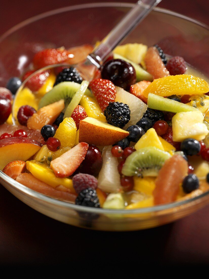 Colourful mixed fruit salad in a glass bowl