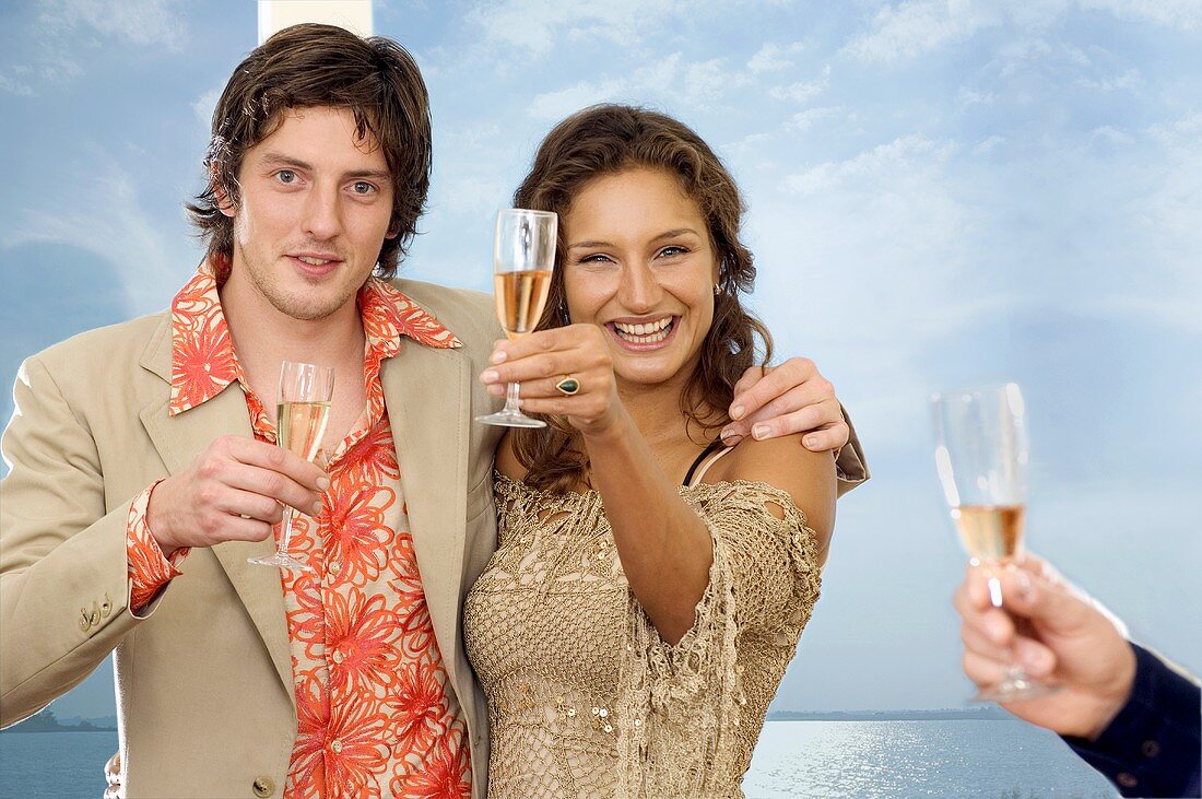 Young couple raising glasses of sparkling wine