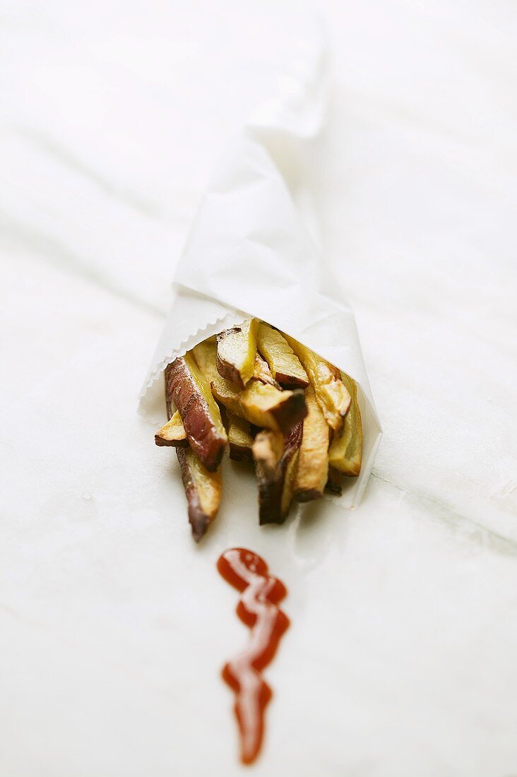 Sweet potato chips in a paper cone with ketchup