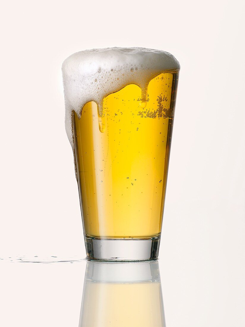 Lager in glass, with foam running over