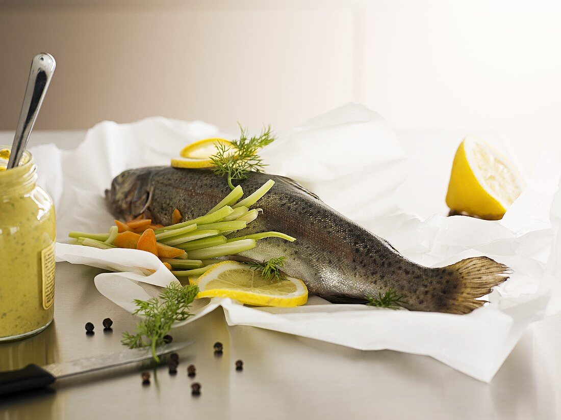 Salmon trout with vegetables on greaseproof paper