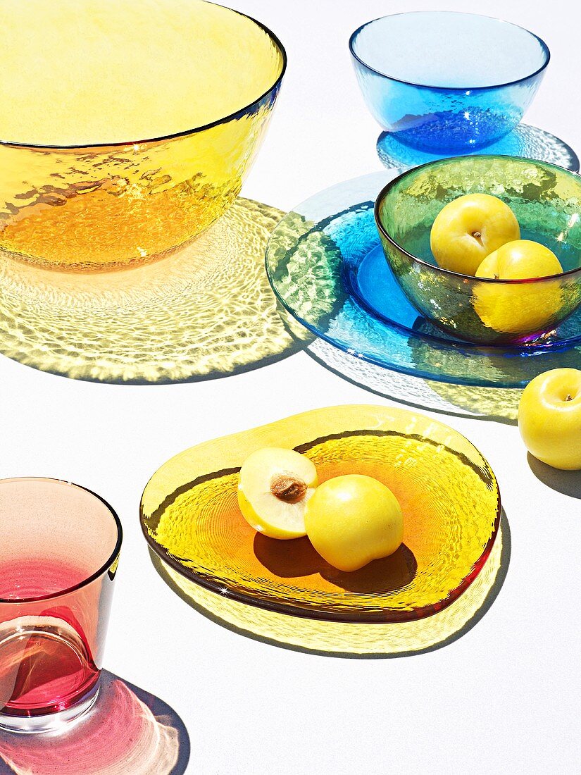 Yellow plums and coloured glass tableware