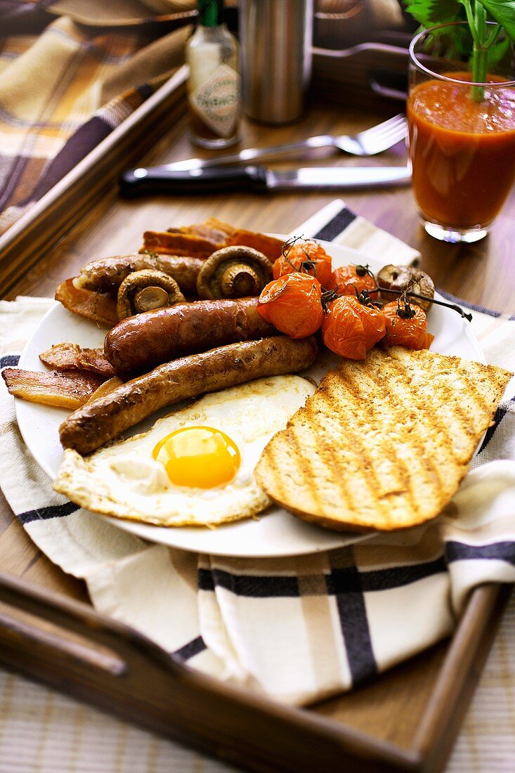English breakfast: bacon, fried egg, sausages, tomato