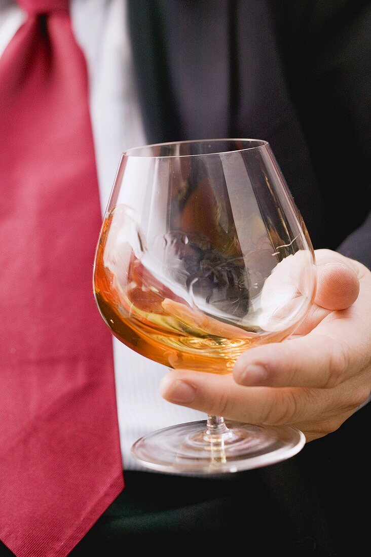 Man swirling cognac in a glass