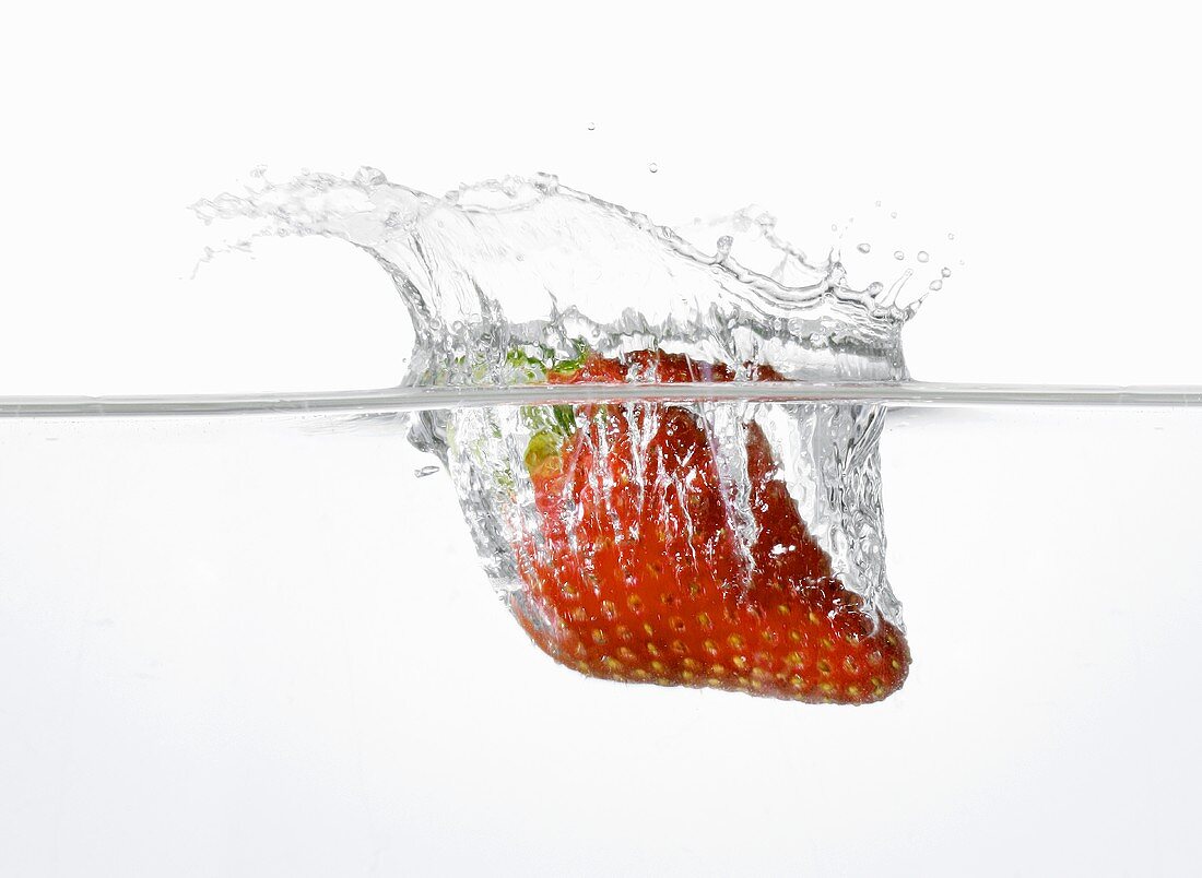 Erdbeere fällt ins Wasser