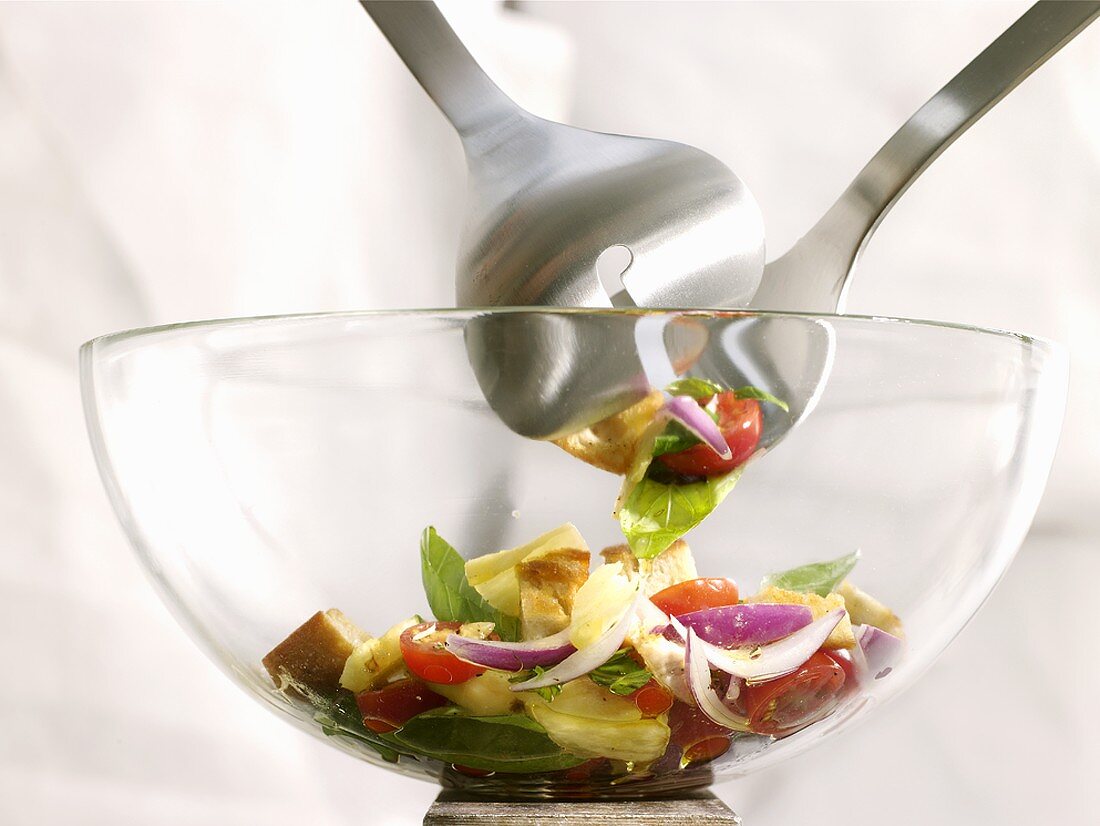 Gemischter Salat in Glasschüssel mit Salatbesteck