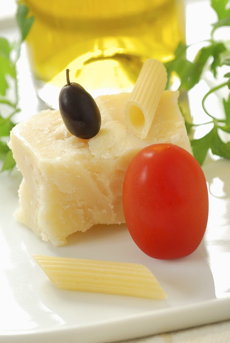 Stillleben mit Tomate, Olive, Parmesan, Penne und Olivenöl