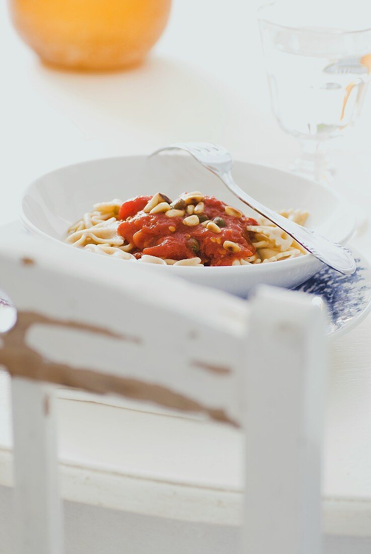 Vollkornfarfalle mit Tomatensugo, Kapern und Pinienkernen