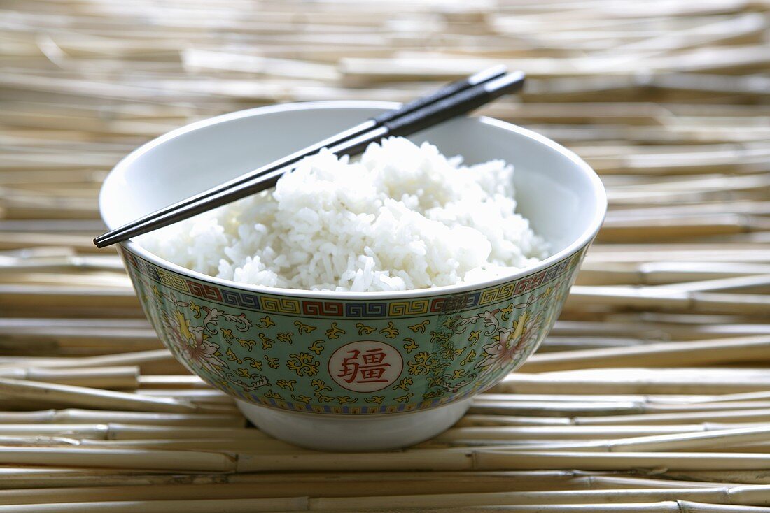 Reis in asiatischer Schale mit Essstäbchen