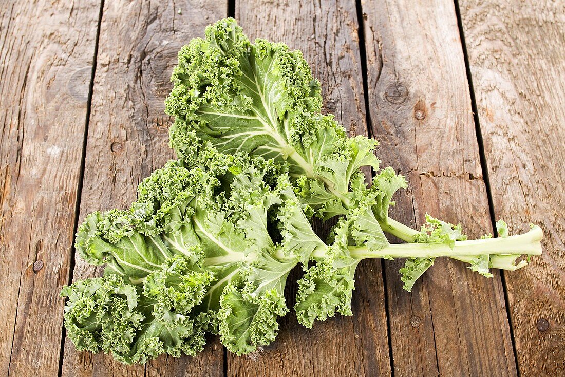Two kale leaves on wooden background