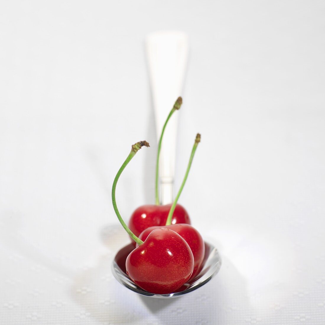 Three cherries on spoon