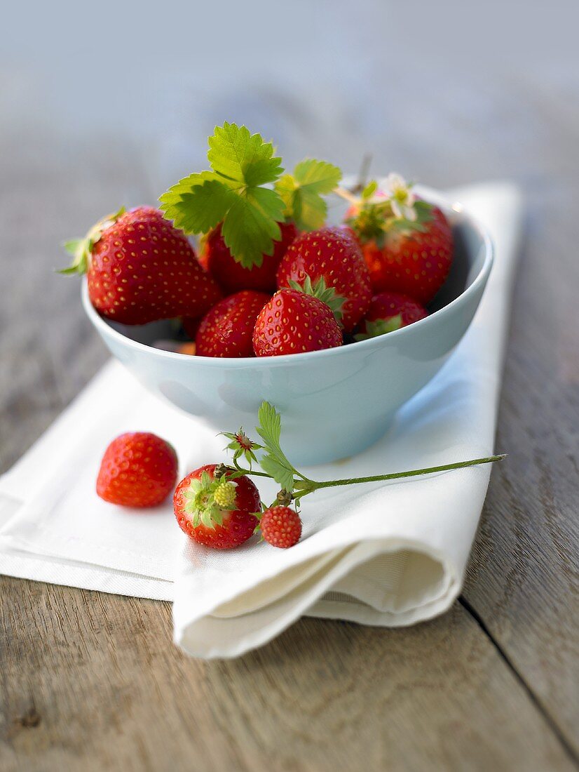 Fresh strawberries in a small bowl on napkin