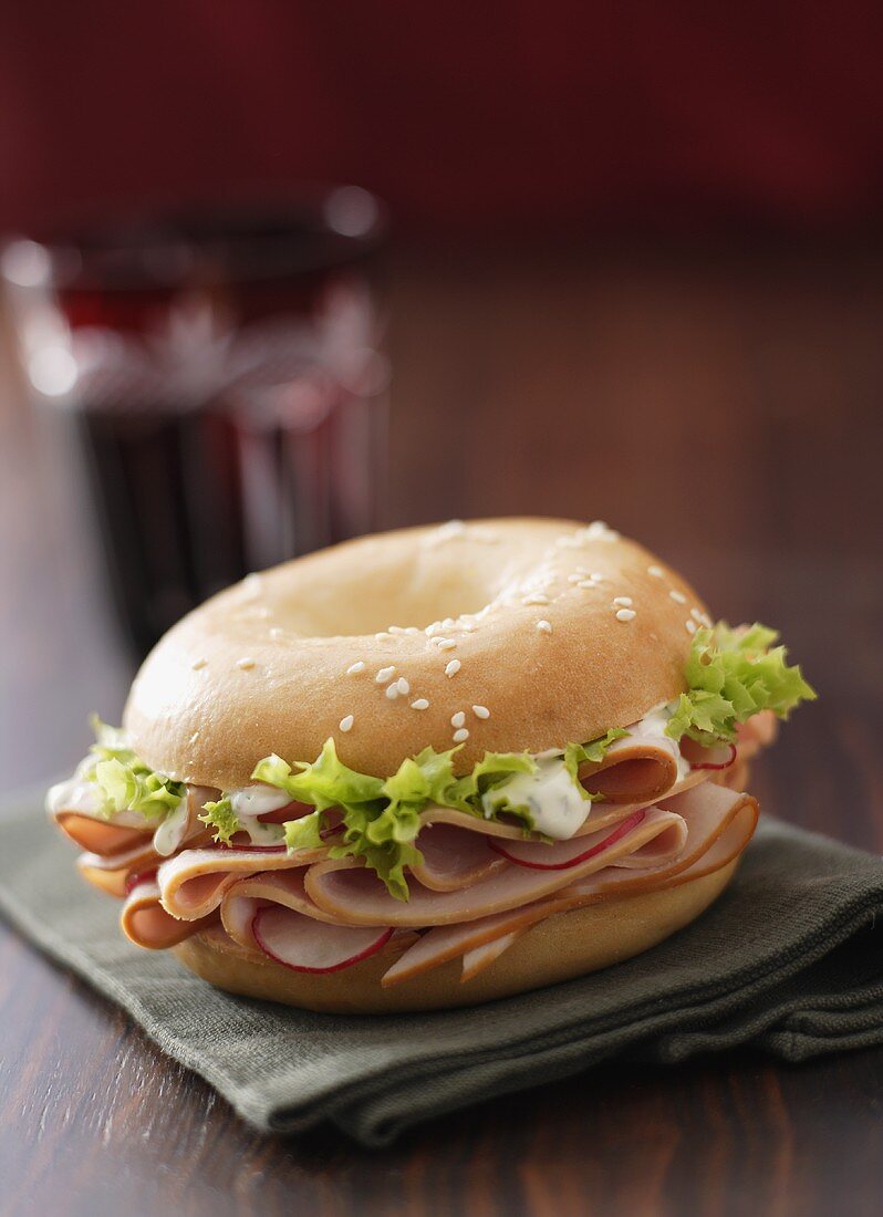 Sesame bagel filled with turkey ham and radishes