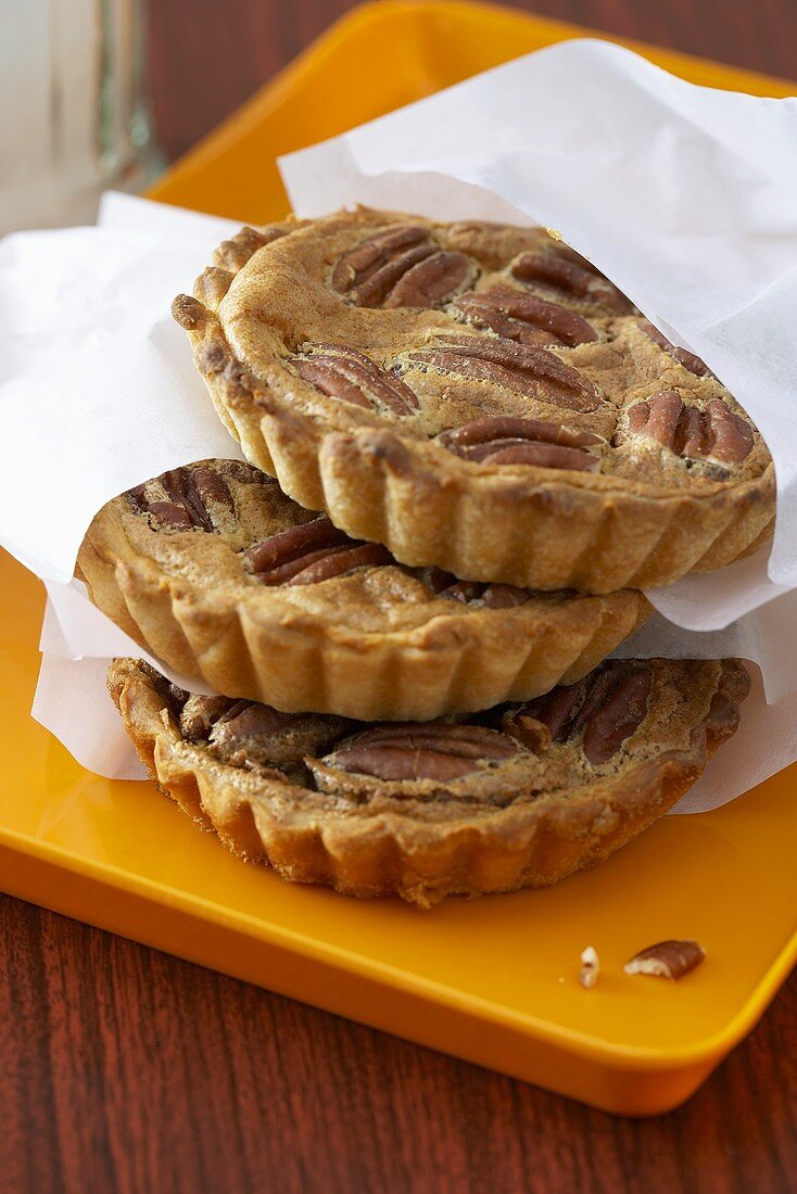 Three small pecan pies in paper bags