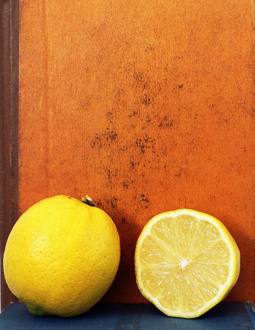 Whole lemon and half a lemon in front of a book